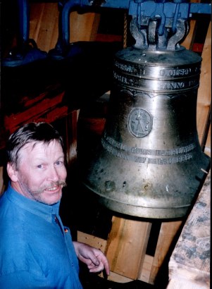 Kirketjener Nils Buverud med den nyeste av kirkens to klokker.
Verger with the bell from 1947.